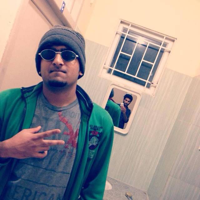 Wearing a beanie and sunglasses with a green jacket