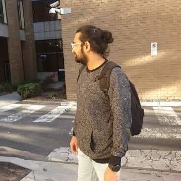 Walking past a campus building with a backpack